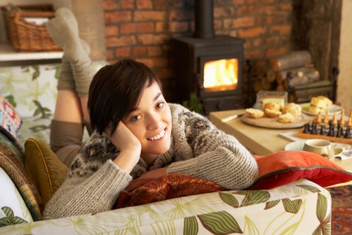 young woman sitting by the fire in her chicago apartment