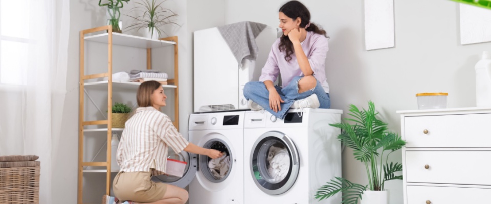 Two people doing laundry in their first college apartment.