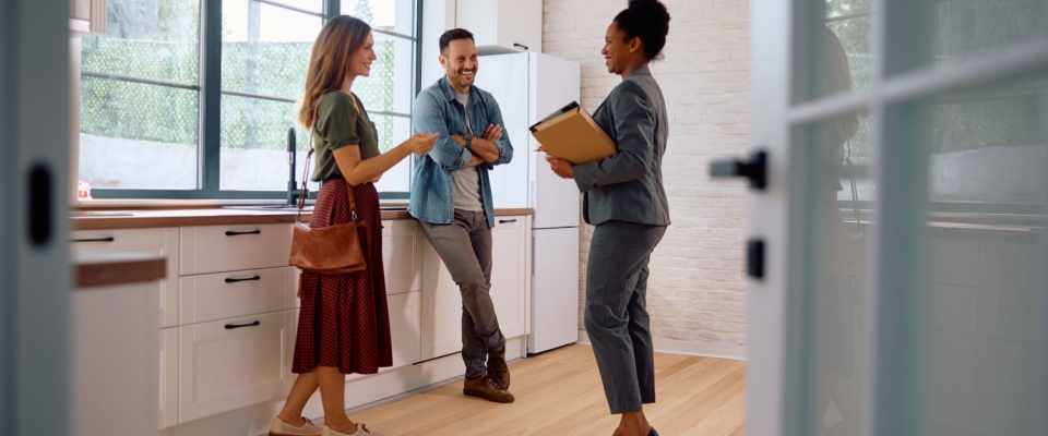 A man and a woman talking to a real estate agent to illustrate an apartment guarantor.