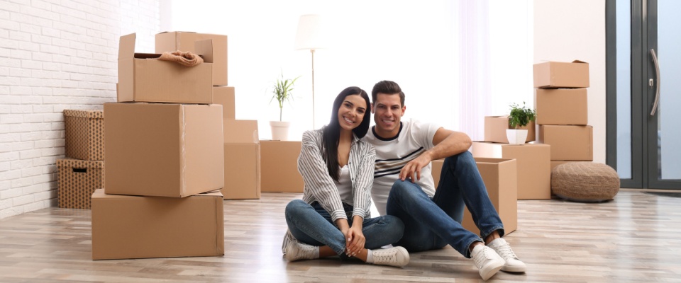 A woman and a man next to boxes in an apartment to illustrate an apartment guarantor.