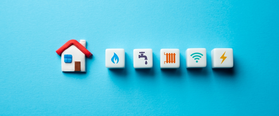 Illustration of a rental house with utility icons for gas, water, heating, internet, and electricity — representing essential home costs for renters.