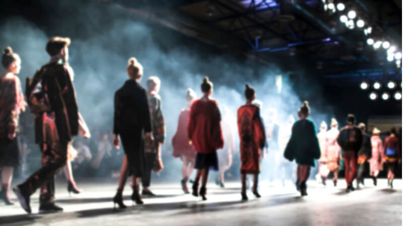 Catwalk models walking towards light