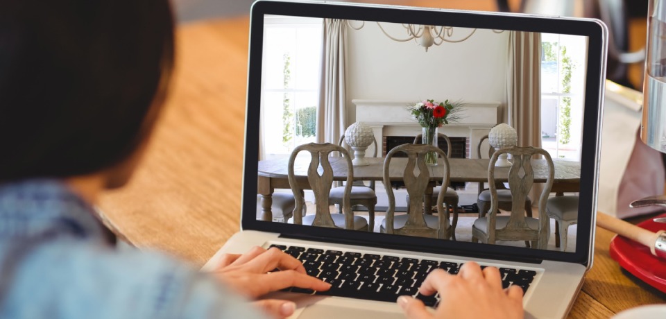 Person using laptop to view elegant dining room interior design online. modern, style, architecture, luxury, technology, browsing to illustrate the pros and cons of virtual tours.