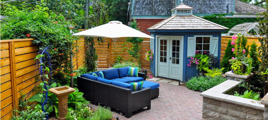 Outdoor sofa in corner of yard with pond and plants