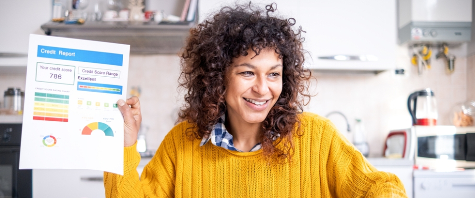 Woman celebrating an excellent credit score after improving finances, showing how renters can move from bad credit apartments to better leasing opportunities.