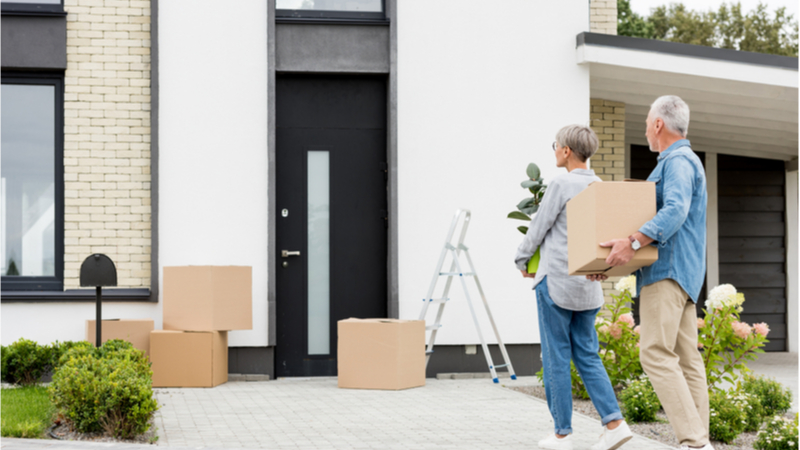 Couple with storage boxes outside home