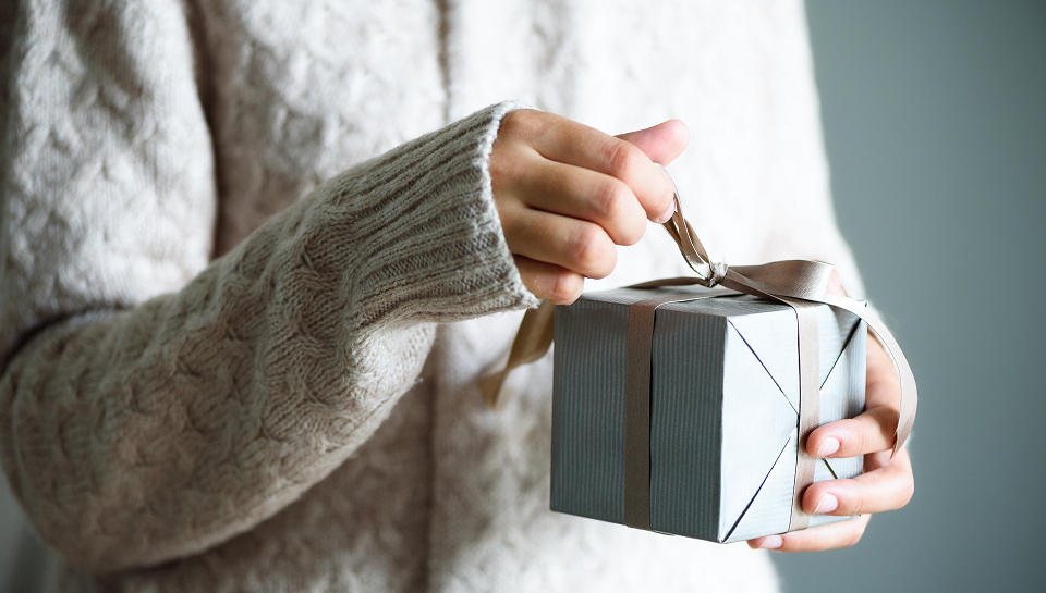 girl in sweater opens gift