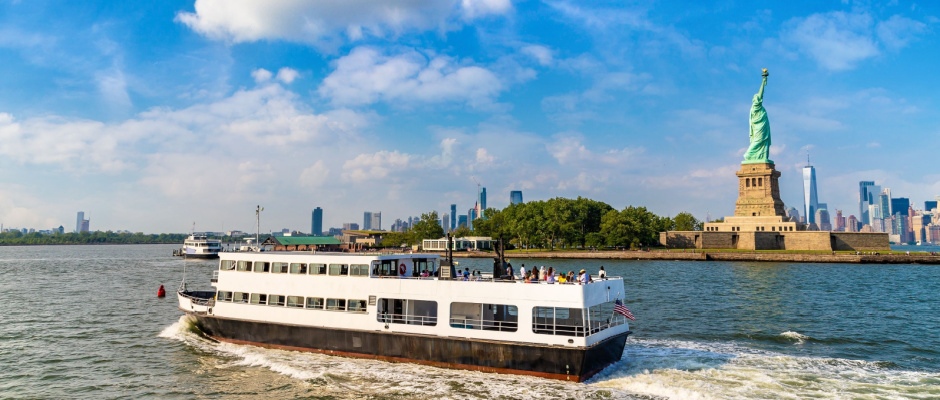 Statue of Liberty and tourist ship ferry in New York City, NY