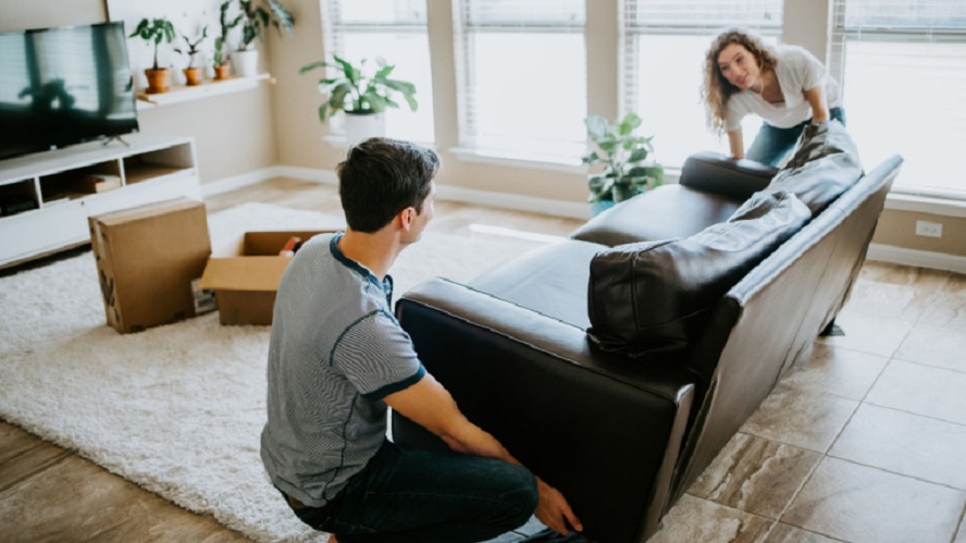 Young Couple Unpacking Large Couch