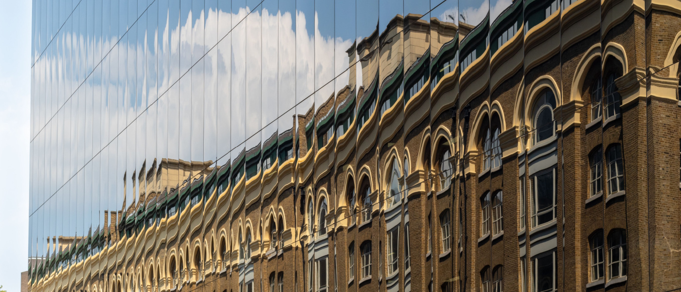 adaptive reuse old building reflecting in new building