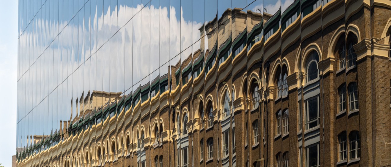 adaptive reuse old building reflecting in new building