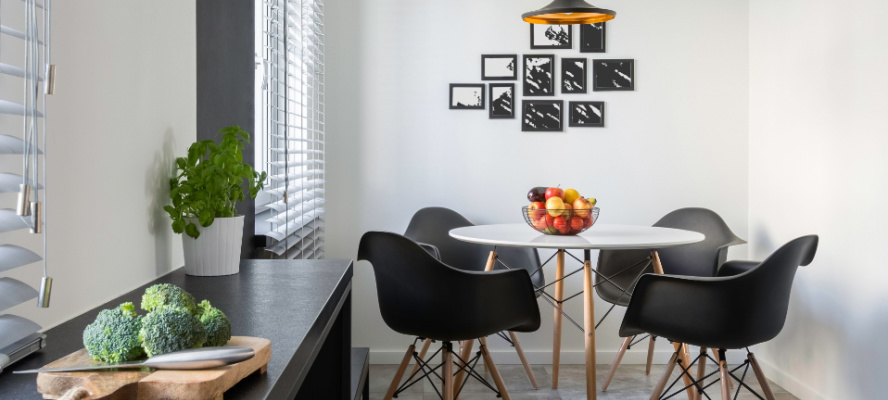 White kitchen with long, granite countertop, round table and chairs