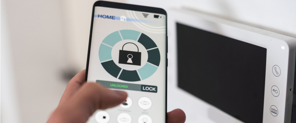 Smartphone with launched application for an alarm security system that locks or unlocks a surveillance camera outside.