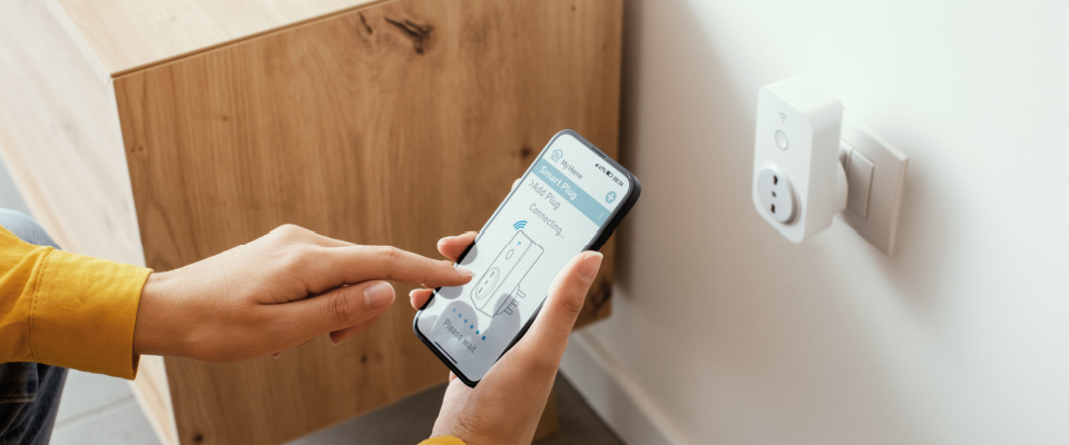 Woman setting a smart plug at in her rental apartment using her smartphone.