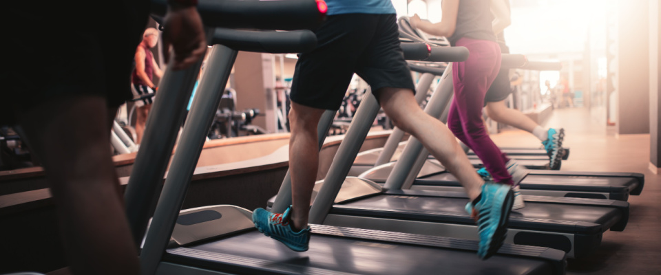 People running on treadmill machines at the fitness club at their apartment building.