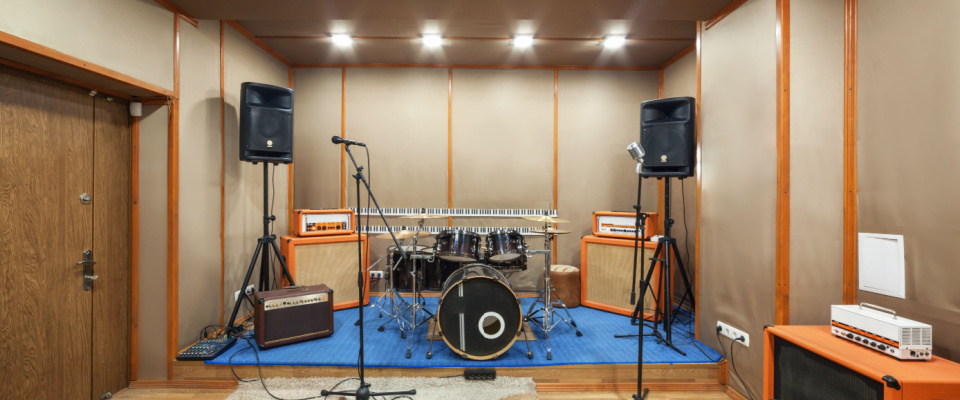 inside of a music room with instruments, microphones and speakers