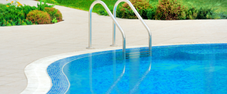 partial view of a swimming pool and a green lawn nearby