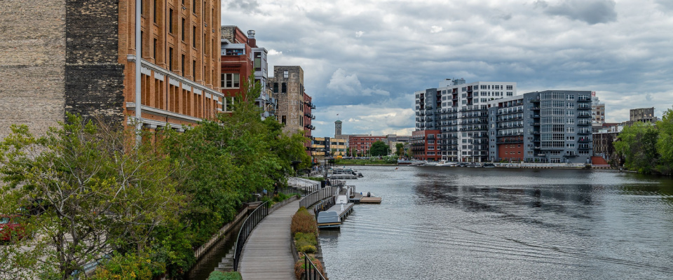 the Milwaukee riverfront with walking lanes and buildings on each bank