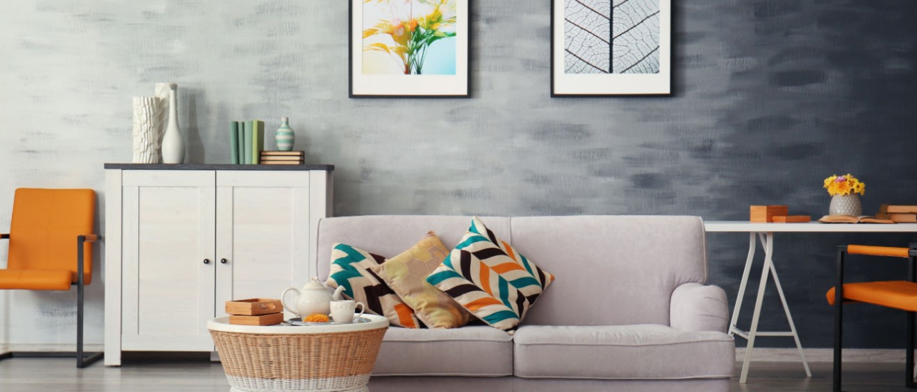apartment interior shot with a sofa, a coffee table, a desk and pictures hanging on the wall