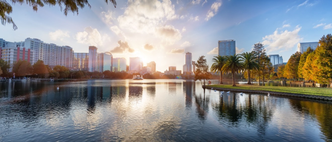 A panoramic image of Orlando, Florida, taken from across a scenic lake reflecting the city’s skyline.