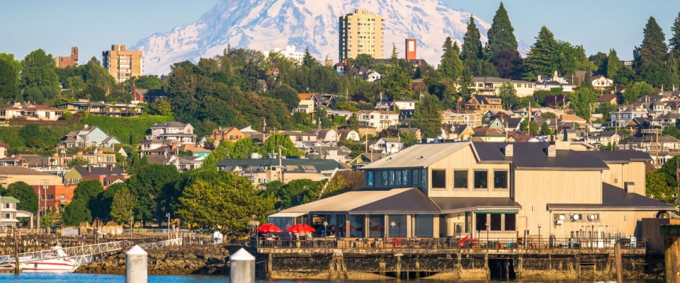 A picturesque view of Tacoma, Washington, with the majestic Mount Rainier in the backdrop, looming over the cityscape.