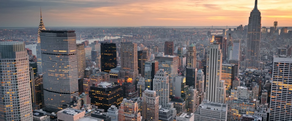 New York City skyline aerial view at sunset with colorful cloud and skyscrapers of midtown Manhattan.