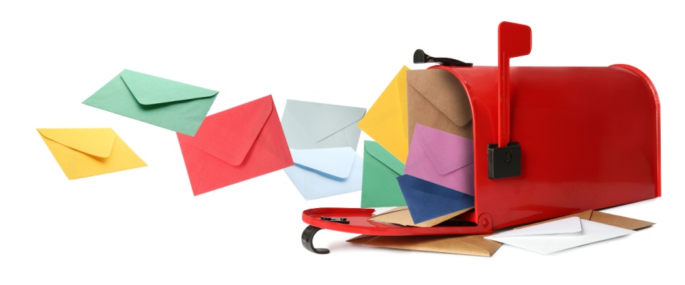 A red mailbox with its door open is overflowing with colorful envelopes, some of which are spilling out.