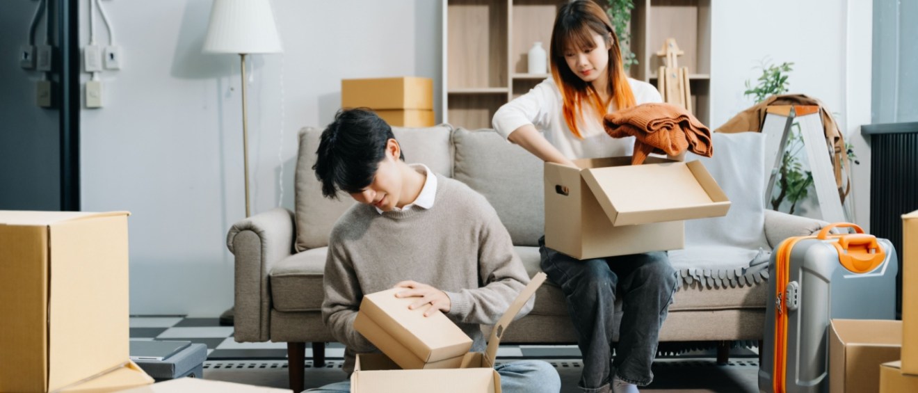 Young couple with big boxes moving into a new rental.