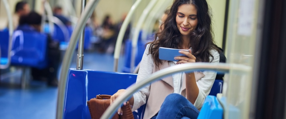 Woman texting on phone while commuting to work.