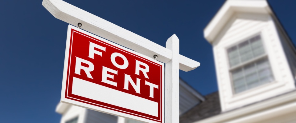 A "For Rent" sign in front of a house, representing a single-family home within a build-to-rent community.