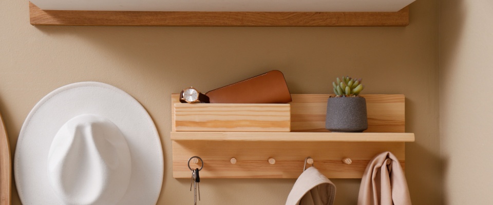 Hallway interior with stylish accessories and wooden hanger for keys on beige wall.