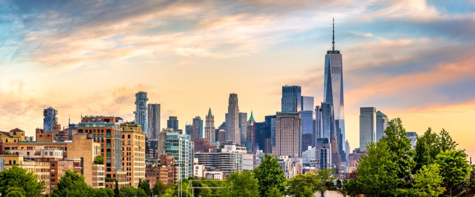 Panoramic view of Lower Manhattan skyline at sunset, behind the Little Island public park.