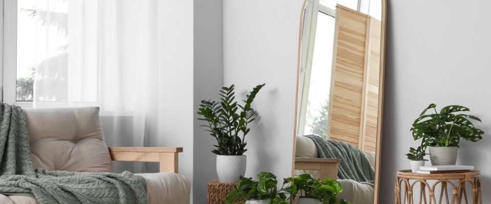 Stylish room interior featuring a large leaning floor mirror, adding elegance and depth to the space.