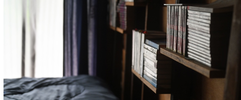 Cozy bedroom with wooden bookshelves filled with books, creating a warm and inviting atmosphere.