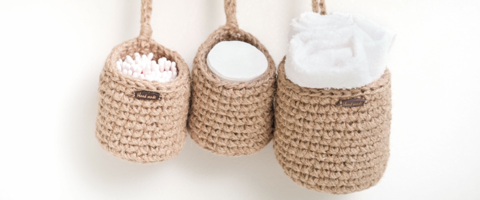 Three small wicker baskets hanging on a bathroom wall, serving as stylish toiletry storage.
