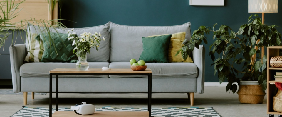 A full view of a snug living room featuring pastel shades and cozy, eco-friendly furniture and decor.