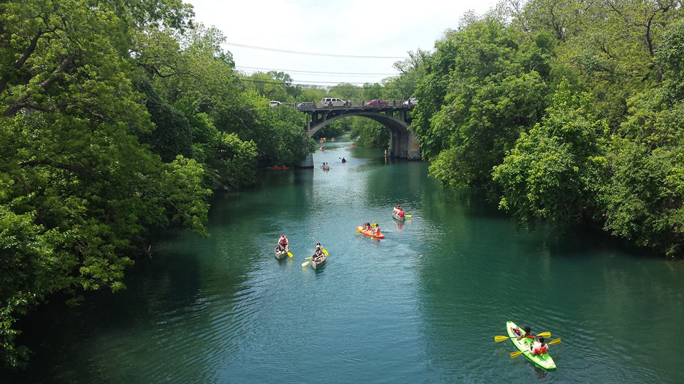 people in kayaks on lady bird lake in austin