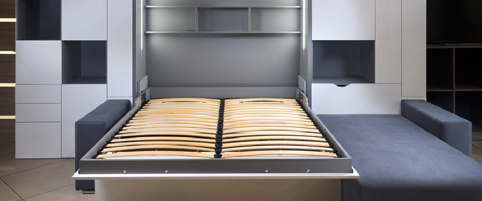 Modern small apartment with a Murphy bed frame integrated into a sleek wall unit to save floor space.