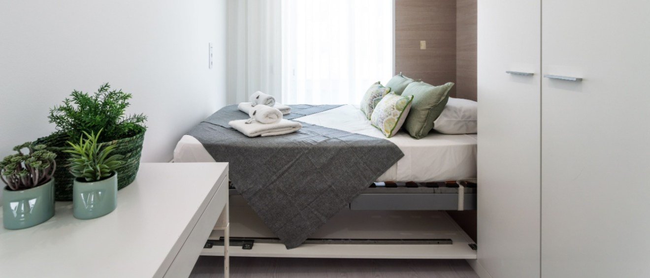 Small room in a compact rental apartment featuring a Murphy bed to maximize space.