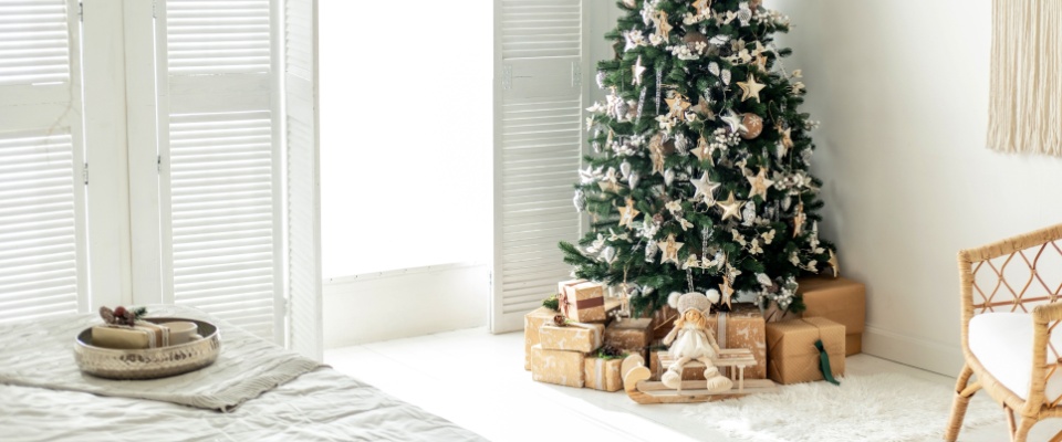 A festive corner featuring a lush Christmas tree adorned with sparkling lights and ornaments.