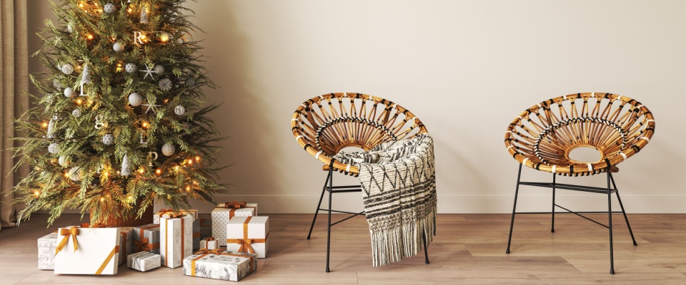 A cozy living room decorated for Christmas in Scandinavian style, featuring a minimalist Christmas tree adorned with ornaments and surrounded by neatly wrapped gift boxes. 