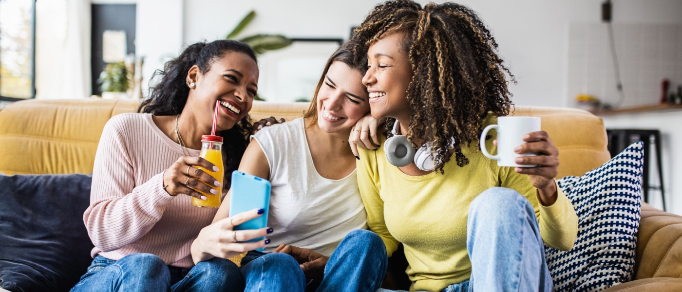 A cheerful scene of three female friends enjoying their free time together at home. T