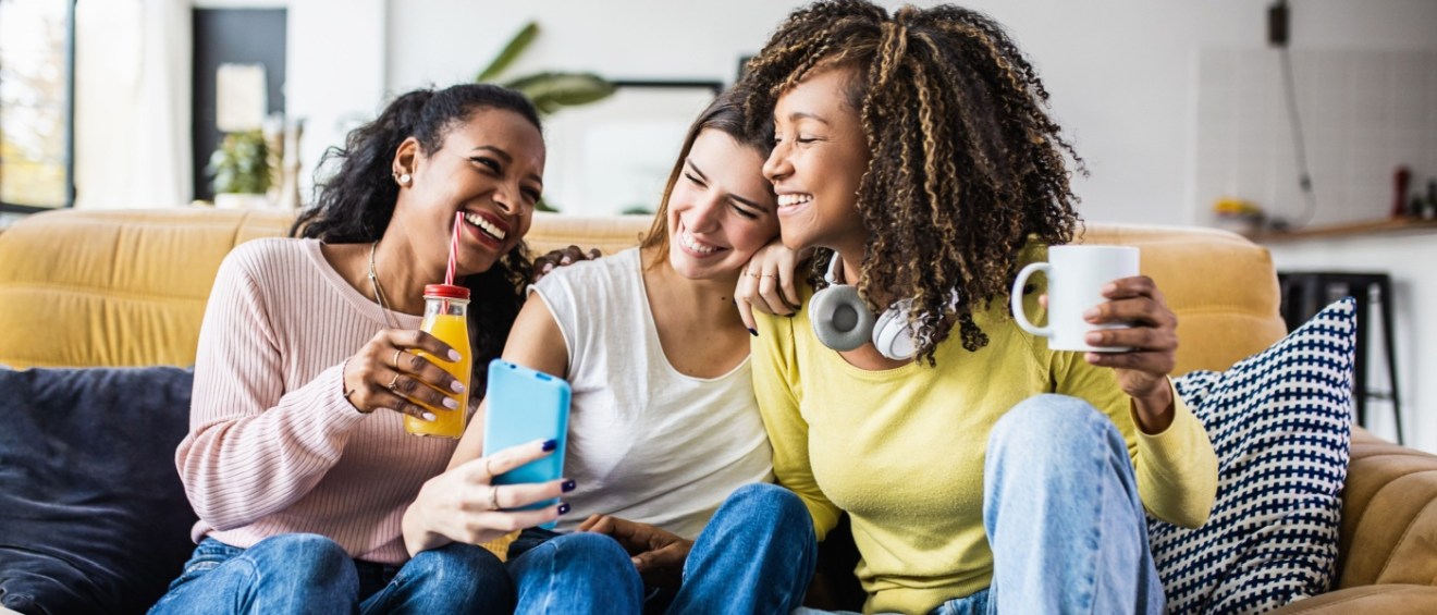 A cheerful scene of three female friends enjoying their free time together at home. T