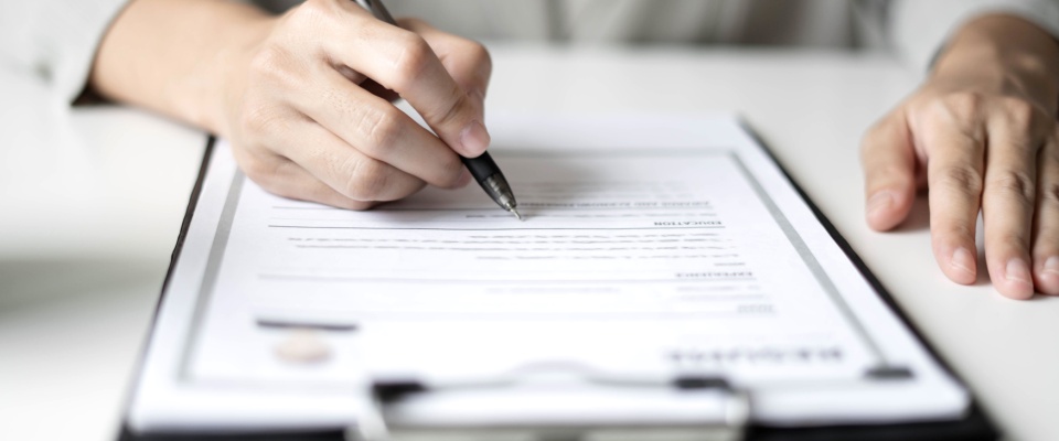 A businesswoman employer holding a resume, reviewing it carefully while preparing to hire a candidate. The scene captures her focus as she analyzes the information before conducting a job interview, highlighting the recruitment and hiring process.