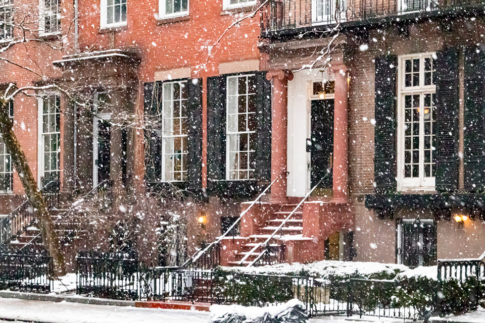 view of brownstones on street with snow