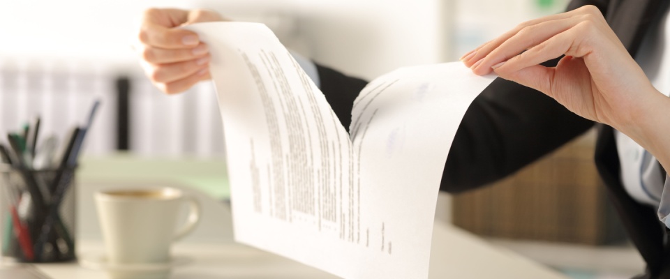 Person tearing a document, symbolizing the process of breaking a lease agreement early.
