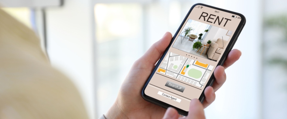 Woman searching for apartments on a rental listings website via smartphone, closeup.