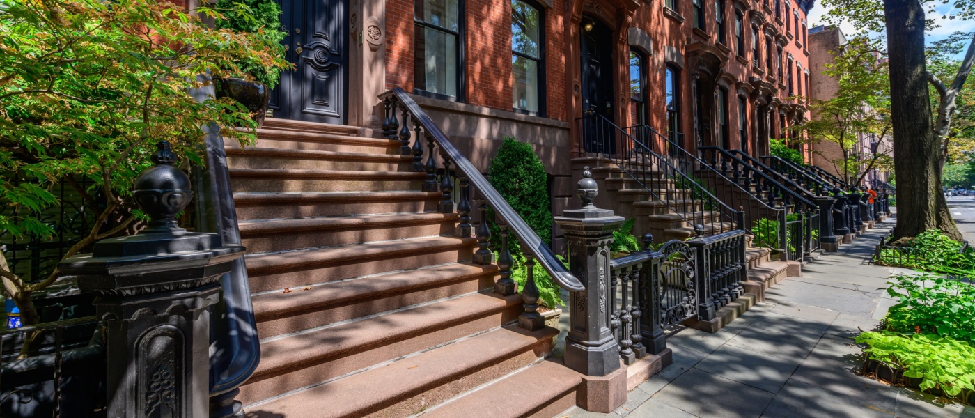Famous Perry Street in the West Village, New York City, featuring historic brownstone townhouses with classic facades, tree-lined sidewalks, and a charming, picturesque neighborhood ambiance.