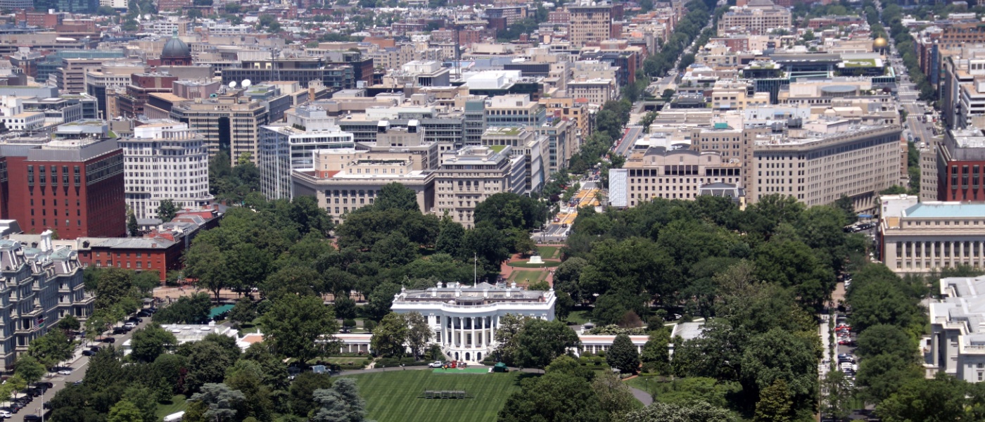 A picturesque view of the White House in Washington, D.C., surrounded by lush greenery and iconic landmarks.