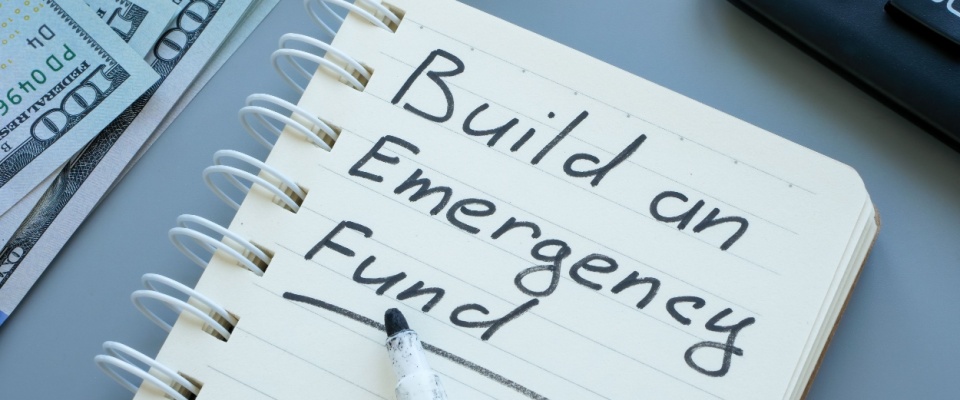 Open notebook with the inscription 'Build an emergency fund' written on the page.